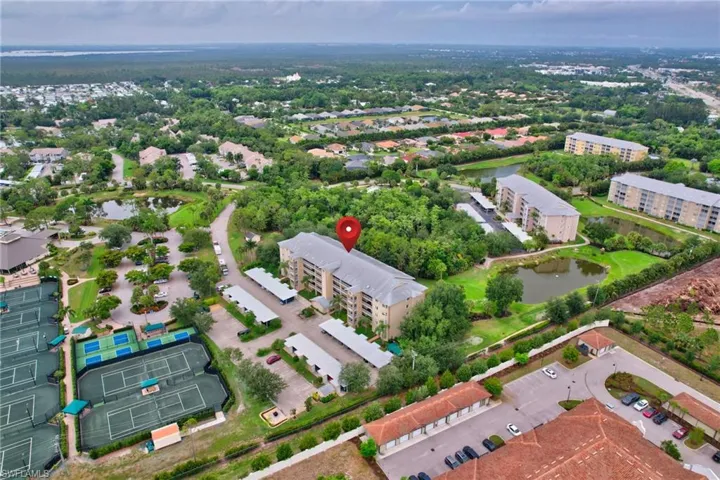 Drone / aerial view of a nearby body of water and apartment complex / building
