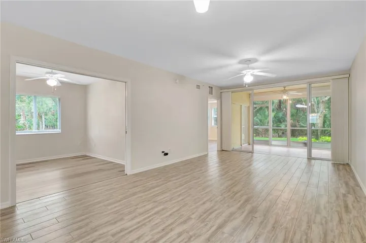 Unfurnished room featuring ceiling fan, light wood-style flooring, and baseboards