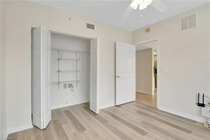 Unfurnished bedroom with light wood-style floors, a closet, baseboards, and a ceiling fan