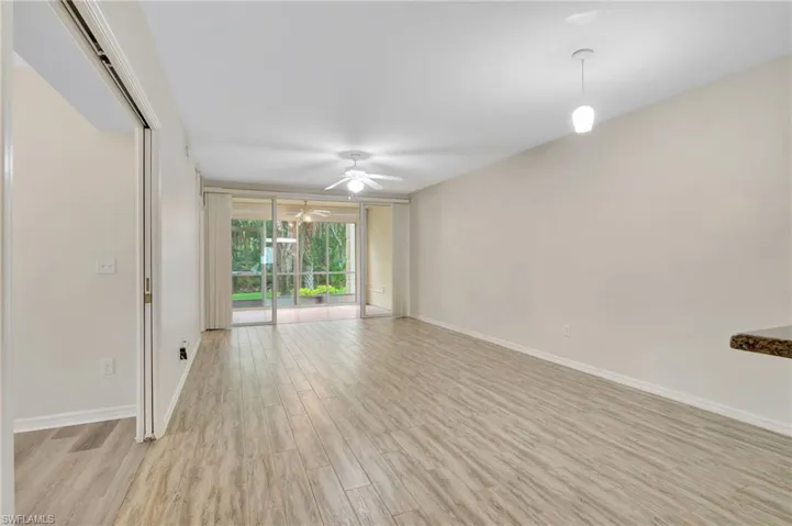 Unfurnished room featuring light wood-type flooring, ceiling fan, and baseboards