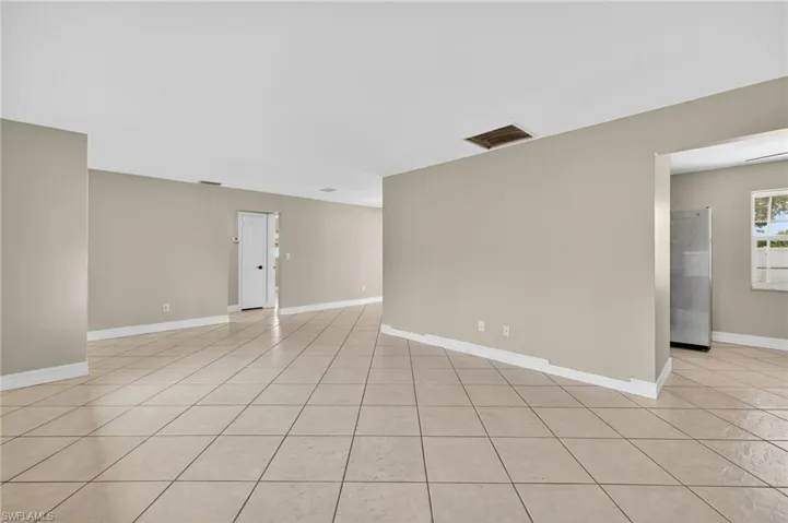 Empty room with light tile patterned flooring and baseboards