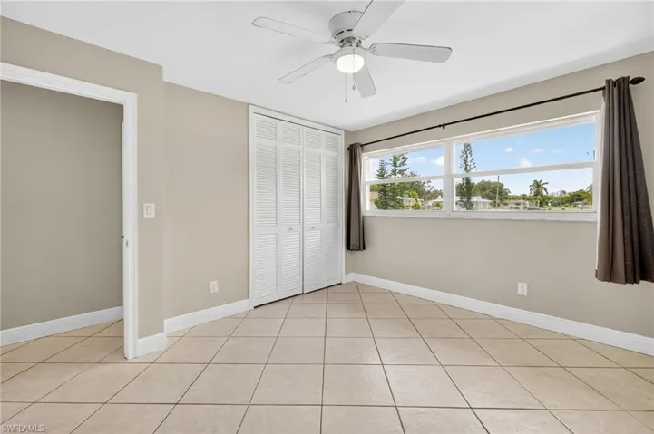 Unfurnished bedroom with a closet, light tile patterned floors, and ceiling fan