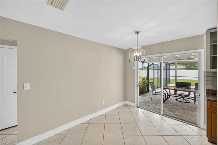 Empty room featuring a chandelier and light tile patterned floors