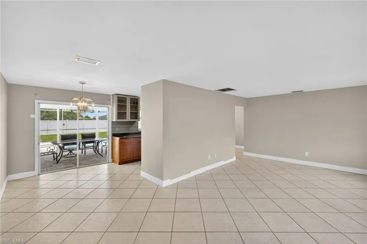 Spare room with a chandelier and light tile patterned flooring