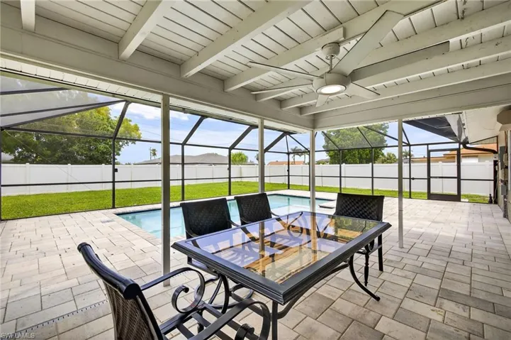 Fenced backyard featuring a ceiling fan, a patio area, and a lanai