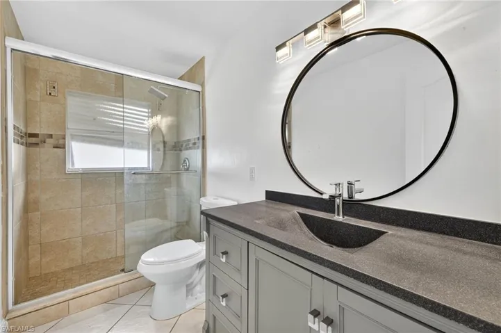 Bathroom with vanity, a stall shower, and tile patterned floors