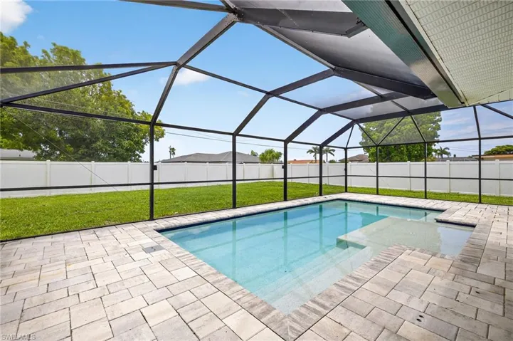 View of swimming pool with a patio, a fenced backyard, and glass enclosure
