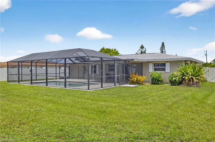 Rear view of house featuring a fenced backyard, stucco siding, a lanai, and a patio area
