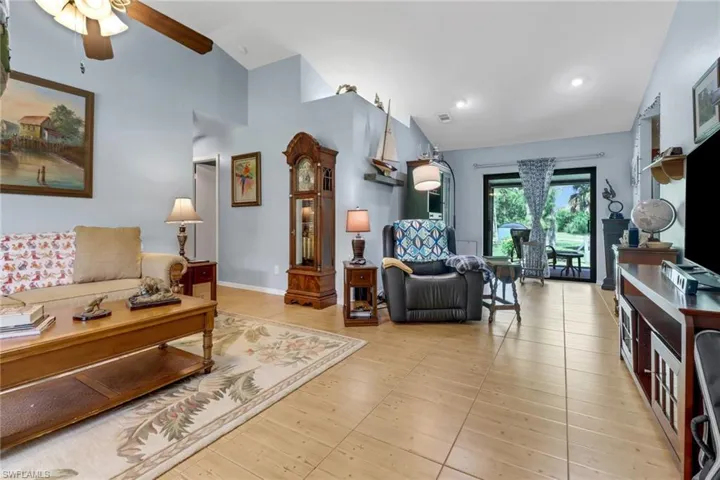 Living room featuring lofted ceiling, ceiling fan, and light hardwood / wood-style floors