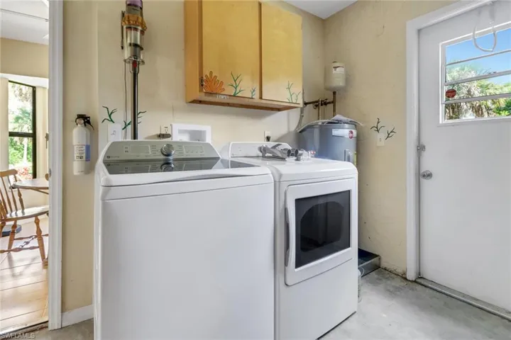Clothes washing area with water heater, washer and dryer, and cabinets