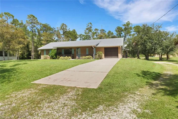 View of front of property with a garage and a front lawn
