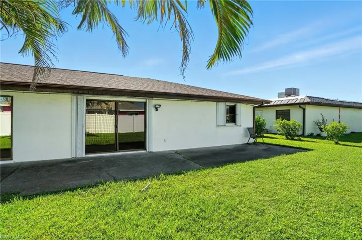 Back of property with a yard, stucco siding, and a patio area