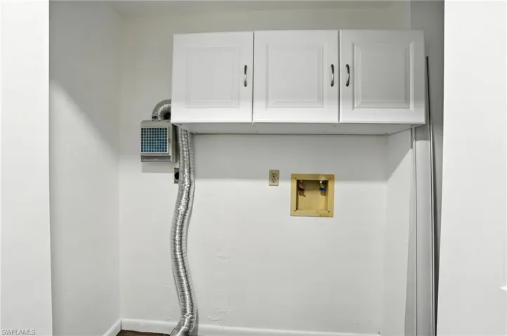 Washroom featuring hookup for a washing machine and cabinet space