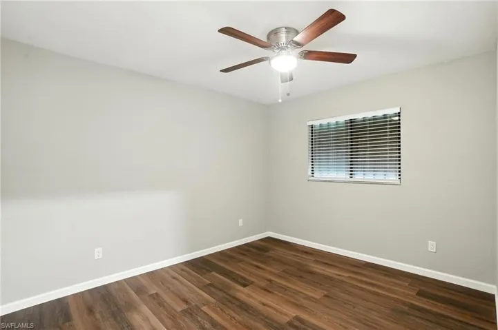 Empty room featuring dark wood-style floors and ceiling fan