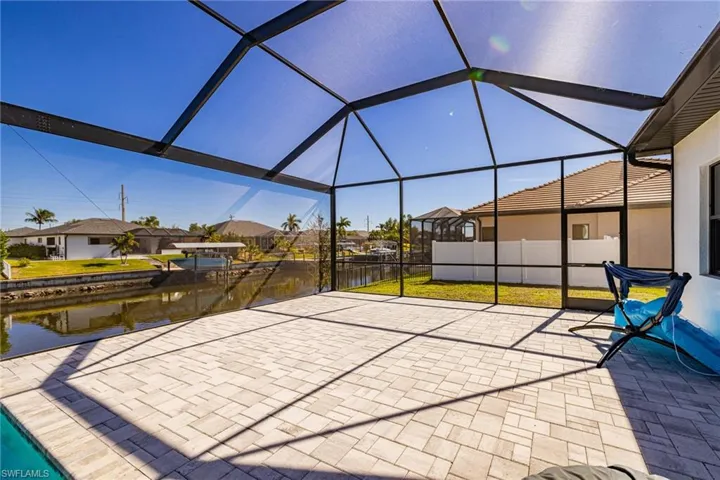 View of patio / terrace featuring a sunroom, a residential view, glass enclosure, and a water view