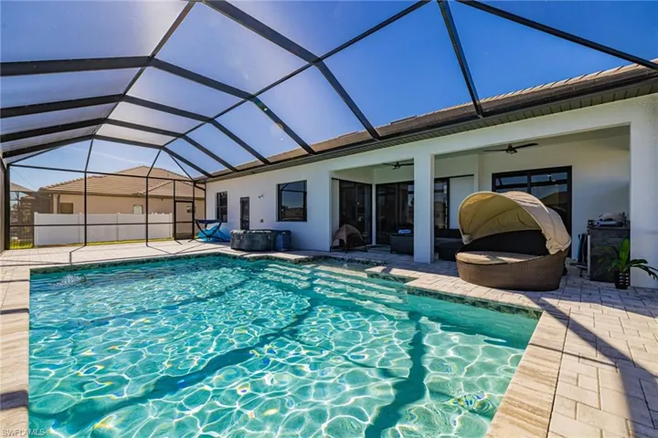 View of swimming pool featuring a sunroom, glass enclosure, and a patio