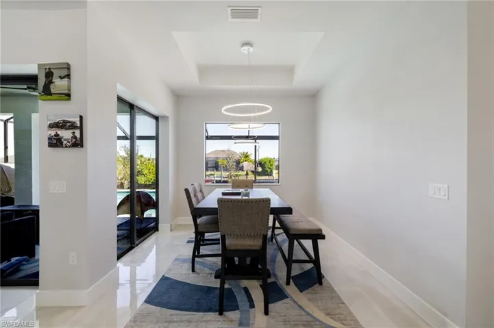 Dining room with a raised ceiling and baseboards