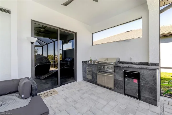 View of patio / terrace featuring an outdoor kitchen, beverage cooler, and a ceiling fan