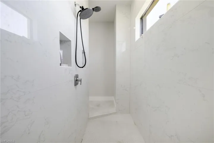 Bathroom featuring a marble finish shower