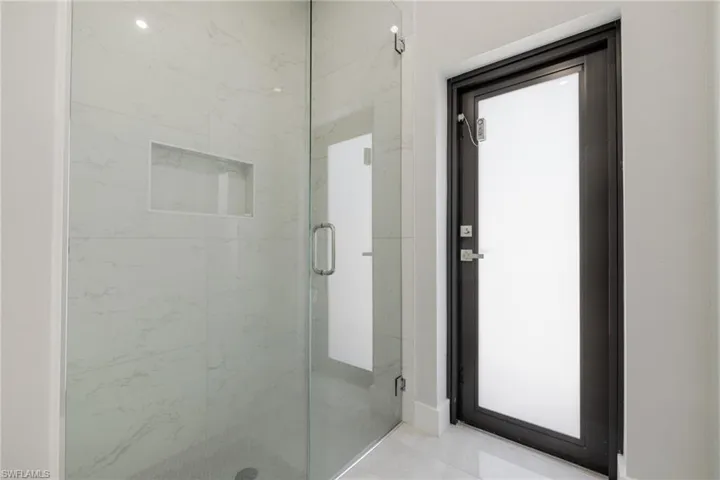 Full bath with a marble finish shower