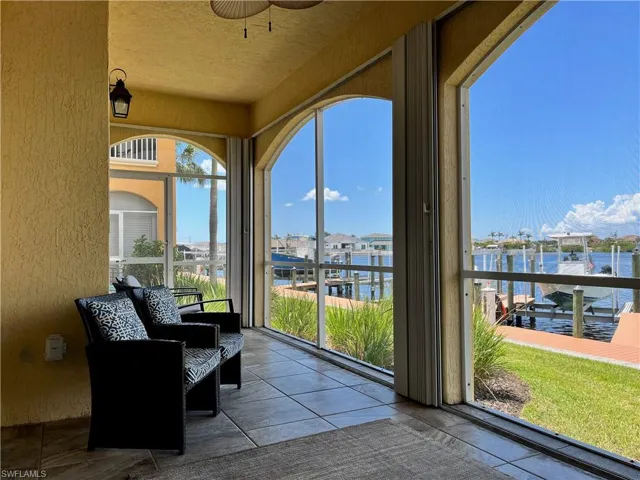 From the comfort of this screened-in lanai, enjoy peaceful views of the canal and boat docks just steps away. Framed by graceful arched openings and cooled by the shade of the covered patio, this inviting outdoor space is perfect for morning coffee, afternoon reading, or evening gatherings. With tile flooring underfoot and a relaxing waterfront backdrop, it’s a true extension of the home’s living space and an ideal spot to soak in the coastal lifestyle.