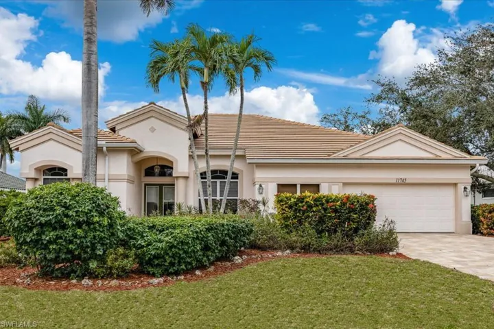 Mediterranean / spanish-style house featuring stucco siding, driveway, a front yard, a garage, and a tiled roof