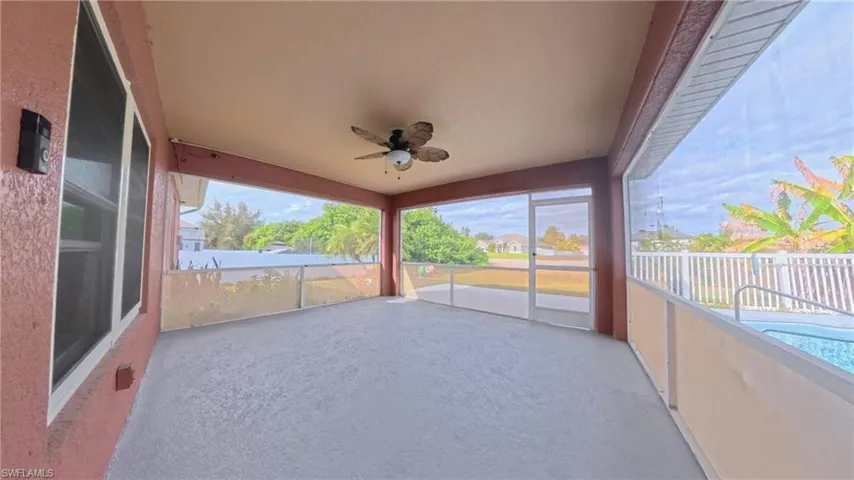 View of screened patio featuring ceiling fan and adjoining pool