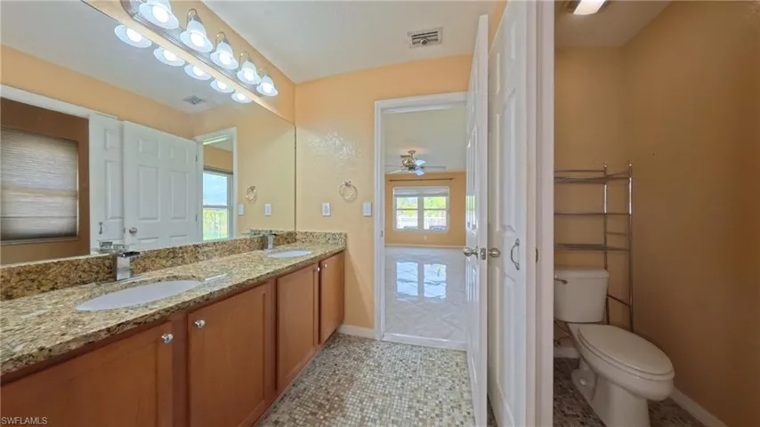 Primary bathroom with double vanity, and patterned flooring tile