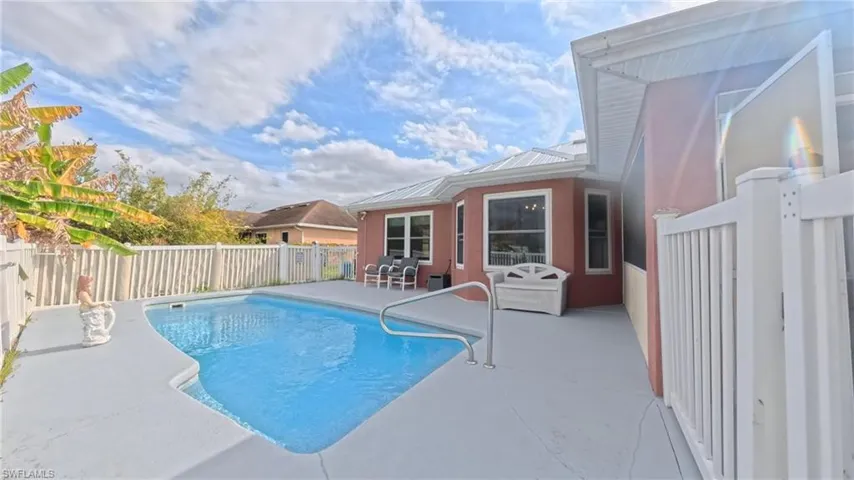 View of fenced in pool featuring patio area for ample seating