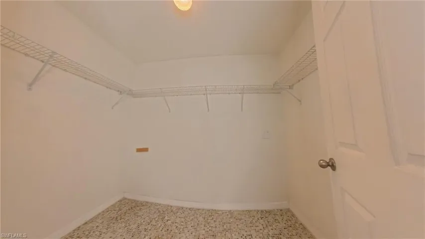 Spacious master closet with tile patterned floors