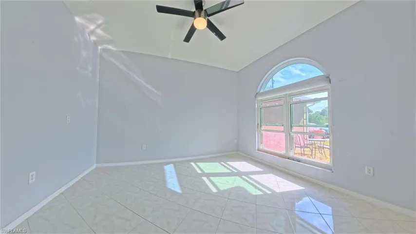 Large den with tiled floors, ceiling fan, and lofted ceiling