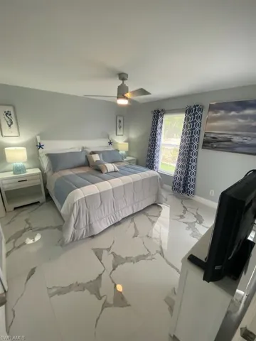 Bedroom featuring marble finish floors and a ceiling fan