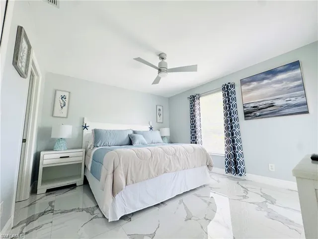 Bedroom with light marble finish flooring and ceiling fan