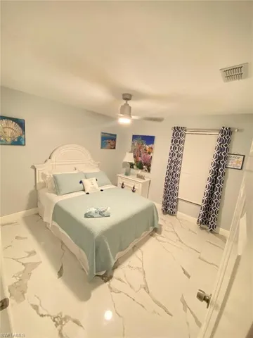 Bedroom with light marble finish flooring and ceiling fan
