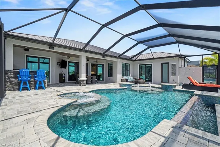 The property features a screened-in lanai with a swimming pool and an integrated hot tub