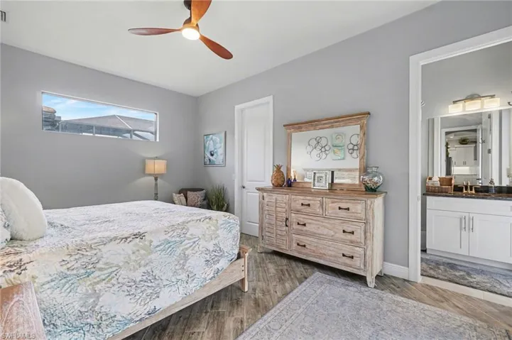 The bedroom features a ceiling fan, a horizontal window, and wood-look flooring