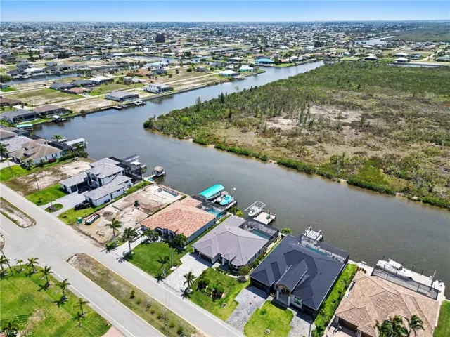 Aerial view showcasing the property's waterfront location, with a private dock providing direct access to the canal