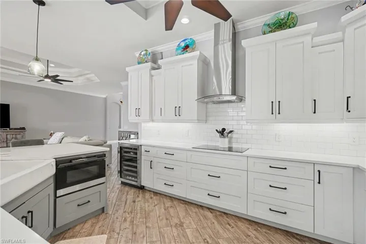The kitchen features white cabinetry, light countertops, and a subway tile backsplash