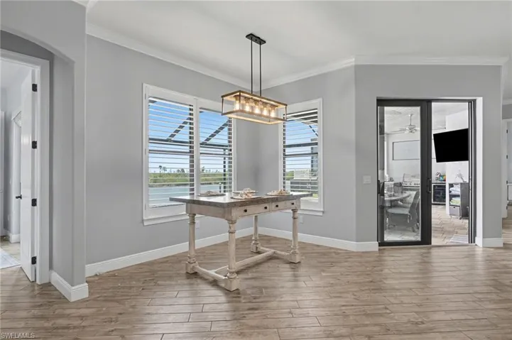 This room features wood-look tile flooring, gray walls, and white crown molding