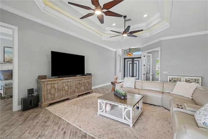 The living area features a coffered ceiling with recessed lighting and ceiling fans, and wood-look tile flooring