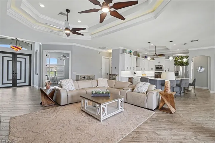 The property features a spacious open-concept living area with tray ceilings and recessed lighting