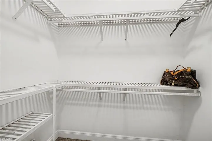 This closet features white walls, white shelving, and white hanging rods