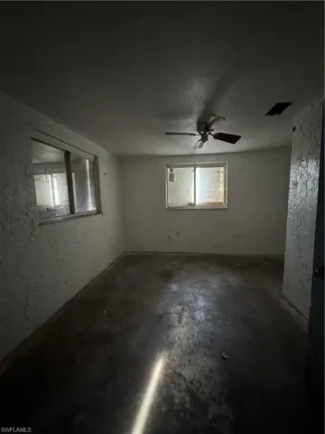 Spare room with concrete floors and a textured ceiling
