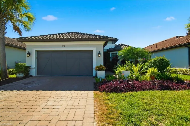 View of front of home featuring decorative driveway, stucco siding, a garage, and a tiled roof