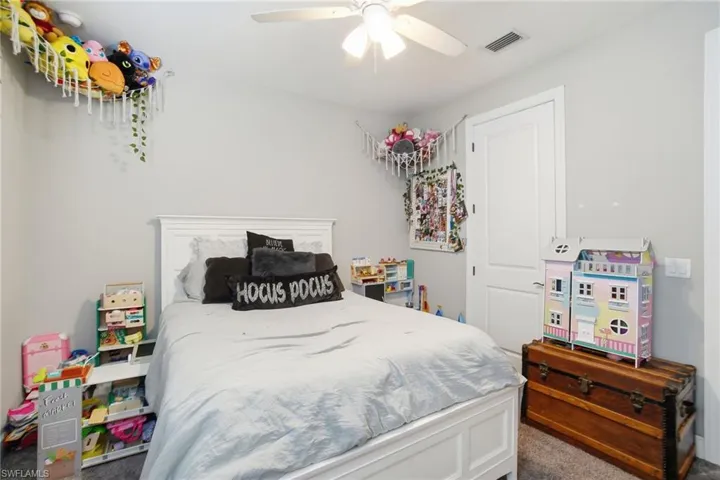 Bedroom featuring dark carpet and a ceiling fan