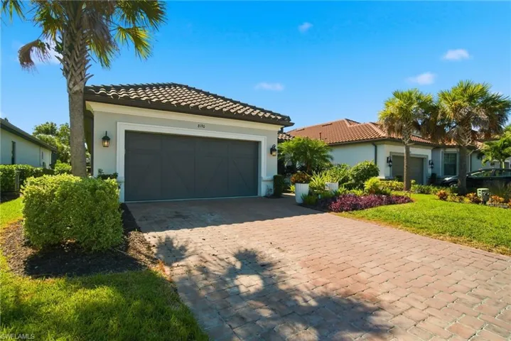 Mediterranean / spanish-style house with stucco siding, decorative driveway, and a tile roof