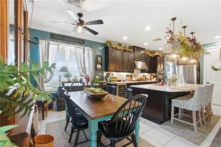 Dining space with light tile patterned floors, crown molding, recessed lighting, and ceiling fan