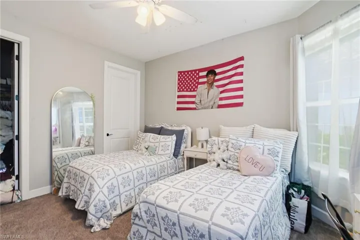 Bedroom with dark carpet and ceiling fan