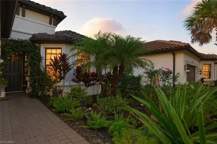Property exterior at dusk featuring a tile roof and stucco siding