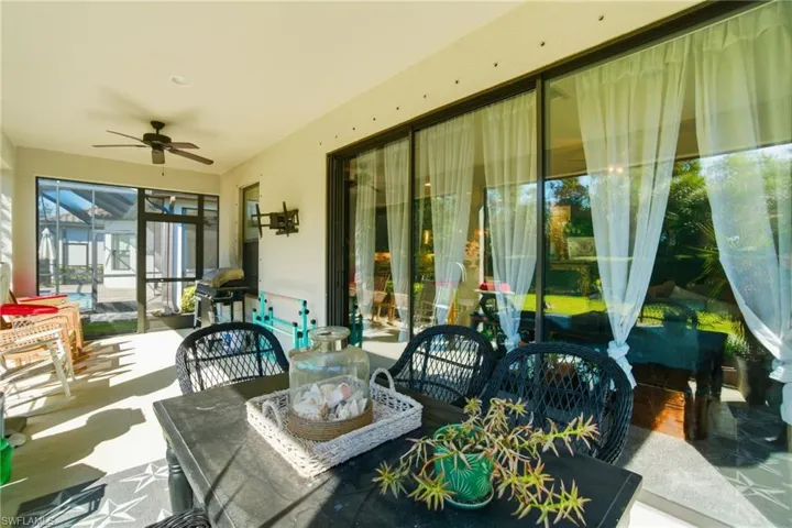 Sunroom with a ceiling fan, outdoor dining area, and a patio